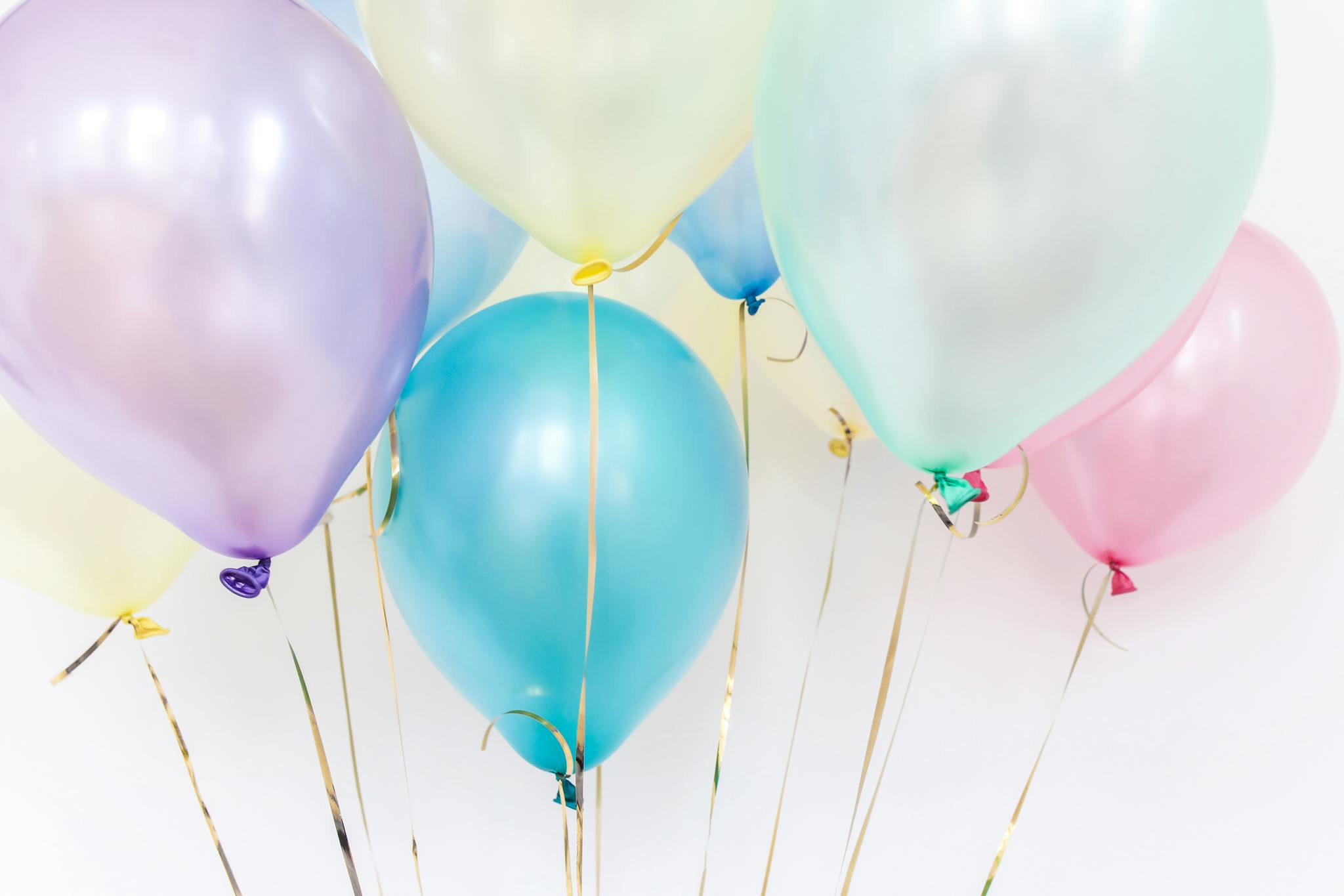 Pastel balloons floating against a neutral background, perfect for festive events.